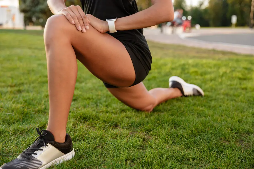 Female athlete stretching to relieve hip pain and improve mobility in Indian Trail NC