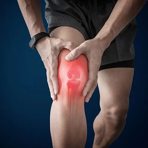 A person holding their knee with a highlighted red pain area, illustrating joint discomfort or injury. Ideal for pages related to knee pain treatment, sports injuries, and rehabilitation services in Indian Trail.