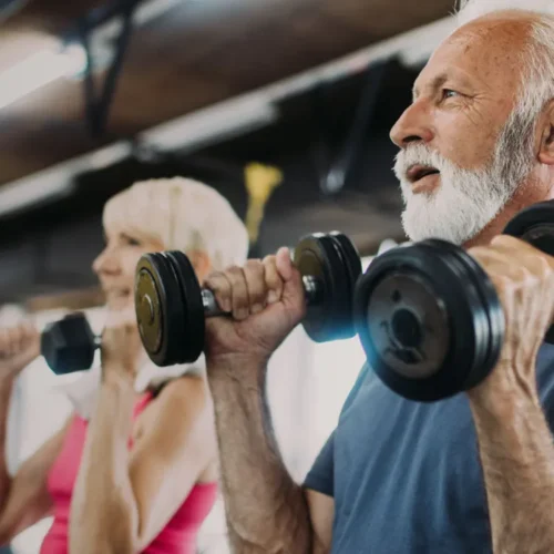 Older adults engage in a focused dumbbell workout, symbolizing the inclusive and energetic spirit of IndianTrail. Great for highlighting fitness programs designed for all ages.