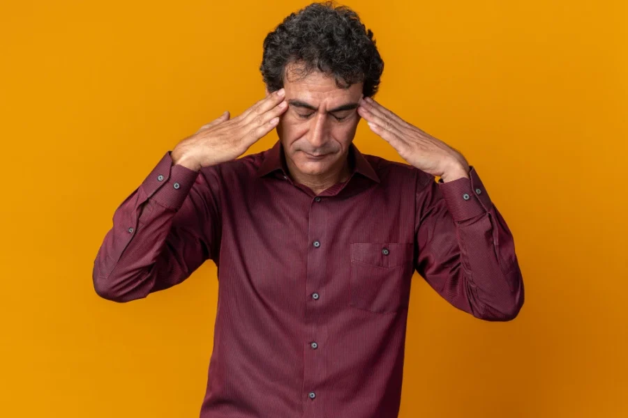 Man holding head due to headache pain and tension