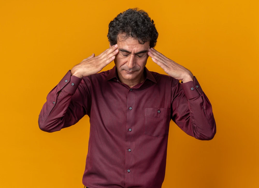 Man holding head due to headache pain and tension