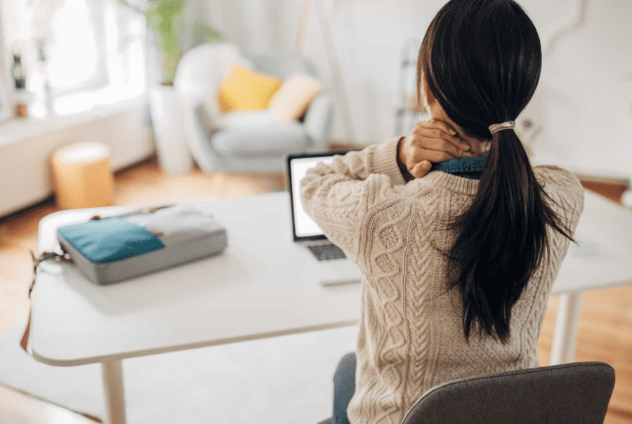 Hurting your spine - a woman sitting at a desk with her back pain
